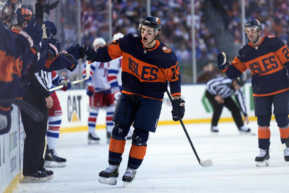 New York Islanders' Mathew Barzal, center, celebrates with teammates after scoring during the first period of an NHL Stadium Series hockey game against the New York Rangers in East Rutherford, N.J., Sunday, Feb. 18, 2024. (AP Photo/Seth Wenig)