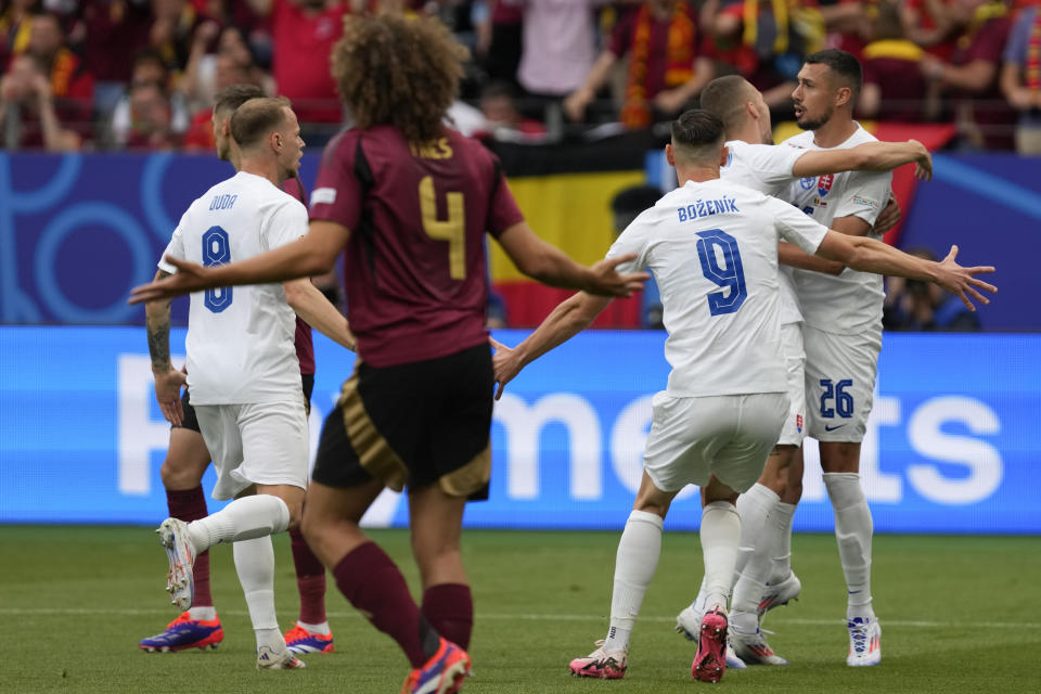 Slovakia's Ivan Schranz, right, is hugged by teammates after scoring during a Group E match between Belgium and Slovakia at the Euro 2024 soccer tournament in Frankfurt, Germany, Monday, June 17, 2024. (AP Photo/Darko Vojinovic)