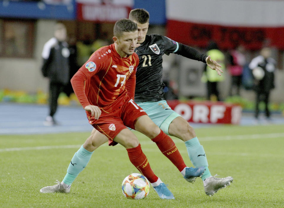 North Macedonia's Enis Bardhi, front, fights for the ball with Austria's Stefan Lainer, during the Euro 2020 group G qualifying soccer match between Austria and North Macedonia at Ernst-Happel stadium in Vienna, Austria, Saturday, Nov. 16, 2019. (AP Photo/Ronald Zak)