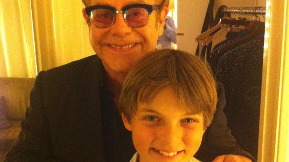 A photo of Elton John holding Damian Hurley's shoulders