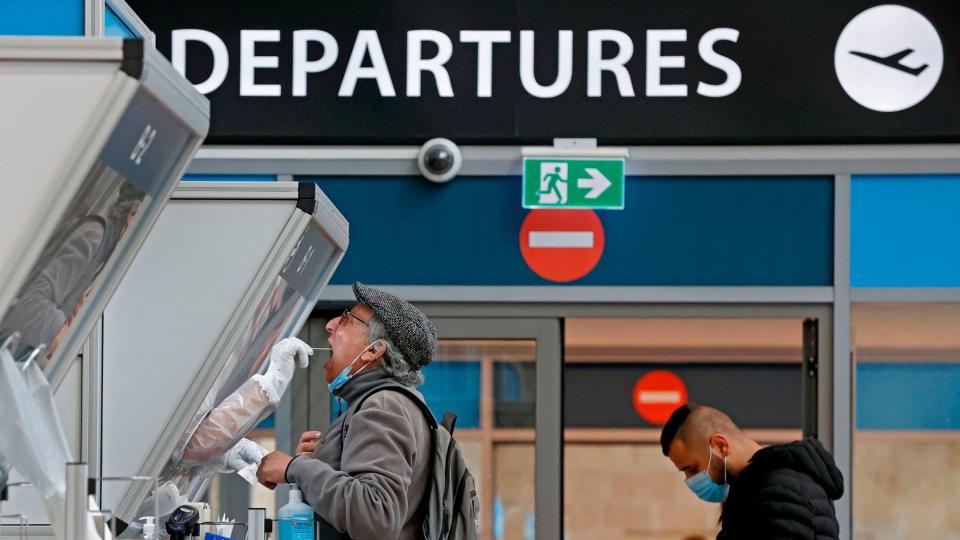 A medic collects a swab sample from a traveller at a booth at the COVID-19 coronavirus rapid testing centre in Israel's Ben-Gurion Airport in Lod, near Tel Aviv, on January 19, 2021.