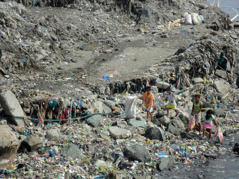 <p>Children collect garbage along Manila Bay in Navotas, Philippines, on July 15, 2015.</p>