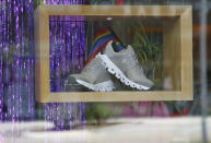 This Thursday, June 20, 2019, photo shows running shoes on display with a rainbow flag at Red Coyote Running and Fitness in Oklahoma City, to celebrate Pride Month. For Pride month, retailers across the country are selling goods and services celebrating LGBTQ culture. Red Coyote Running and Fitness on Saturday sponsored an inaugural “Love Run” race, complete with rainbow medals. (AP Photo/Sue Ogrocki)