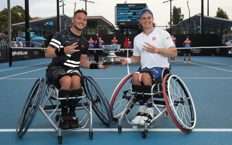 Alfie Hewett and Gordon Reid of Great Britain pose with the trophy after their victory in the Men's Wheelchair Doubles Final match against Gustavo Fernandez of Argentina and Shingo Kunieda of Japan during day 10 of the 2022 Australian Open at Melbourne Park on January 26, 2022 in Melbourne, Australia. - GETTY IMAGES