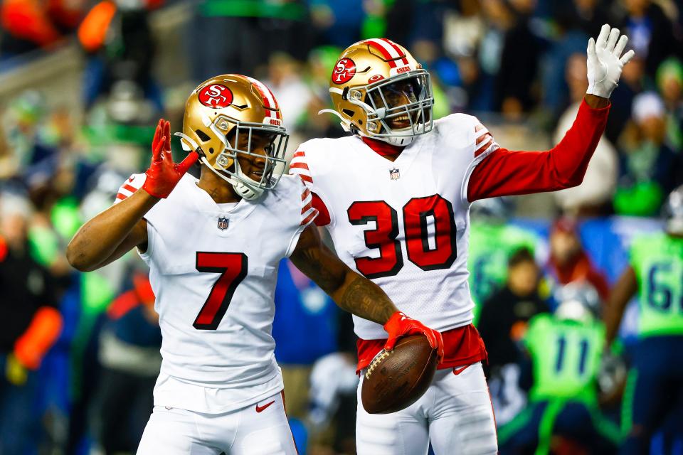 San Francisco 49ers cornerback Charvarius Ward (7) and safety George Odum (30) celebrate following a fumble return by Ward against the Seattle Seahawks.