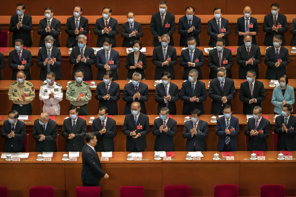 Delegates applaud as Chinese President Xi Jinping arrives for the closing session of China's National People's Congress (NPC) in Beijing, Thursday, May 28, 2020. China's ceremonial legislature has endorsed a national security law for Hong Kong that has strained relations with the United States and Britain. (AP Photo/Mark Schiefelbein)