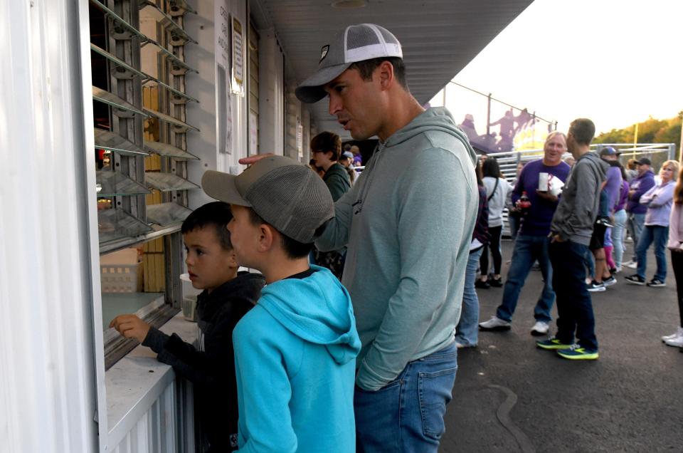 Michael Sirpilla and sons Hudson, 6, and Roman, 8, of Jackson Township make a stop at the concession stand before the start of Jackson's Oct. 6 game versus the Canton McKinley Bulldogs at Robert Fife Stadium in Jackson.