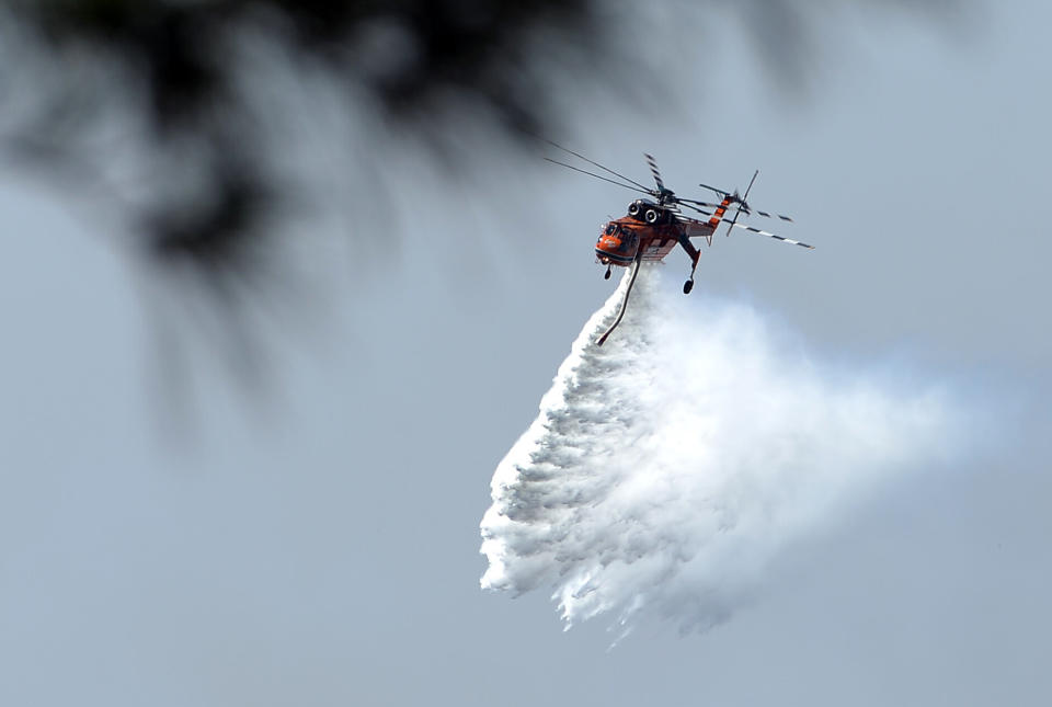 A helicopter drops water to douse bushfires along the Linksview Road near Faulconbridge in the Blue Mountains on October 23, 2013. (SAEED KHAN/AFP/Getty Images)