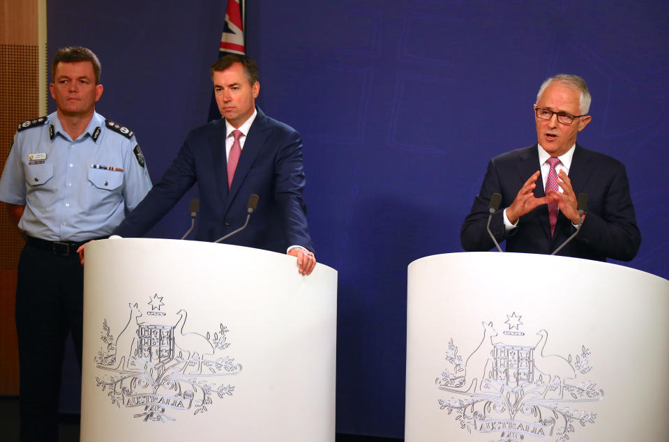 Australian Prime Minister Malcolm Turnbull speaks as the Federal Minister for Justice Michael Keenan and the Australian Federal Police Commissioner Andrew Colvin listen on during a media conference in Sydney, Australia, December 23, 2016 regarding a plot to attack prominent sites in the city of Melbourne with a series of bombs on Christmas Day that authorities described as "an imminent terrorist event" inspired by Islamic State. REUTERS/David Gray