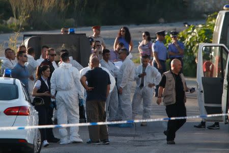 Police and forensics experts stand behind a road block after a powerful bomb blew up a car killing investigative journalist Daphne Caruana Galizia in Bidnija, Malta, October 16, 2017. REUTERS/Darrin Zammit Lupi