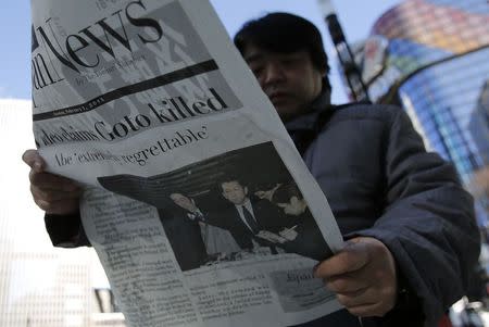 A man reads an extra edition of a newspaper, which reported that Islamic State militants said they had beheaded Japanese journalist Kenji Goto, in Tokyo's Ginza district February 1, 2015. REUTERS/Toru Hanai