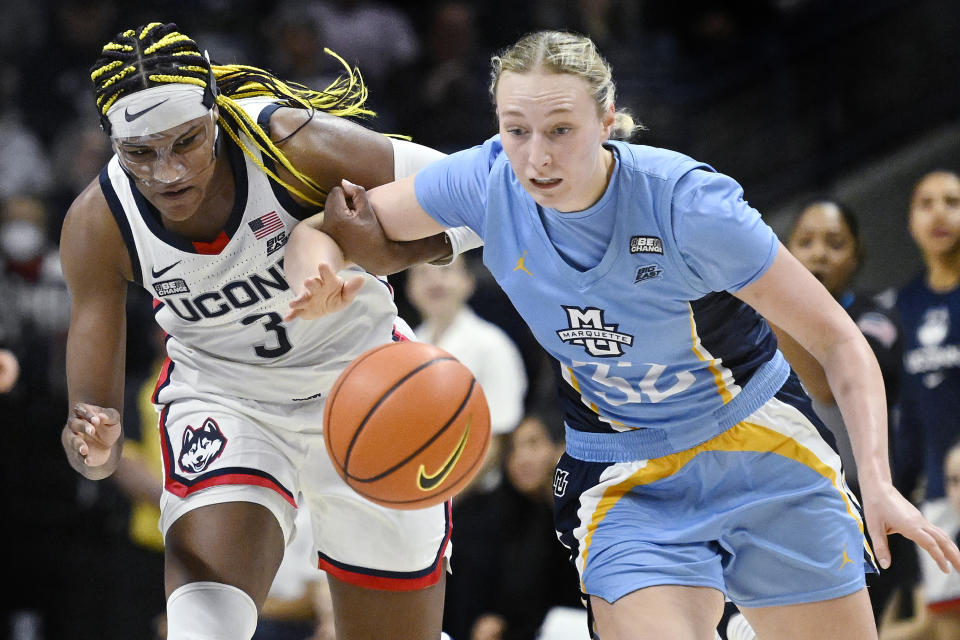 Connecticut's Aaliyah Edwards (3) links arms with Marquette's Liza Karlen (32) as they chase the ball in the first half of an NCAA college basketball game, Saturday, Dec. 31, 2022, in Storrs, Conn. (AP Photo/Jessica Hill)