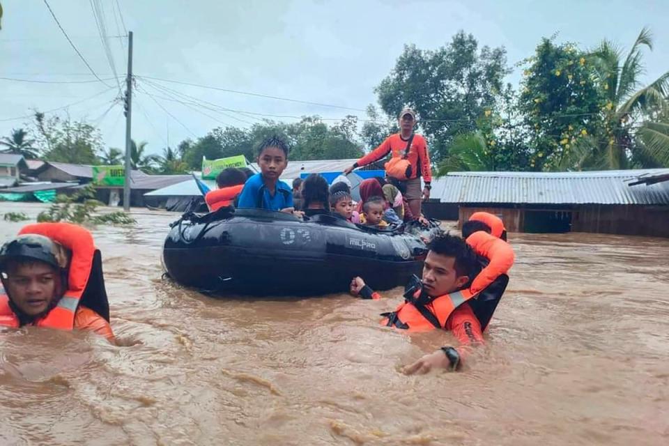 Rescue workers evacuating people from a flooded area in Parang, Maguindanao province (Philippine Coast Guard (PCG)/AFP)