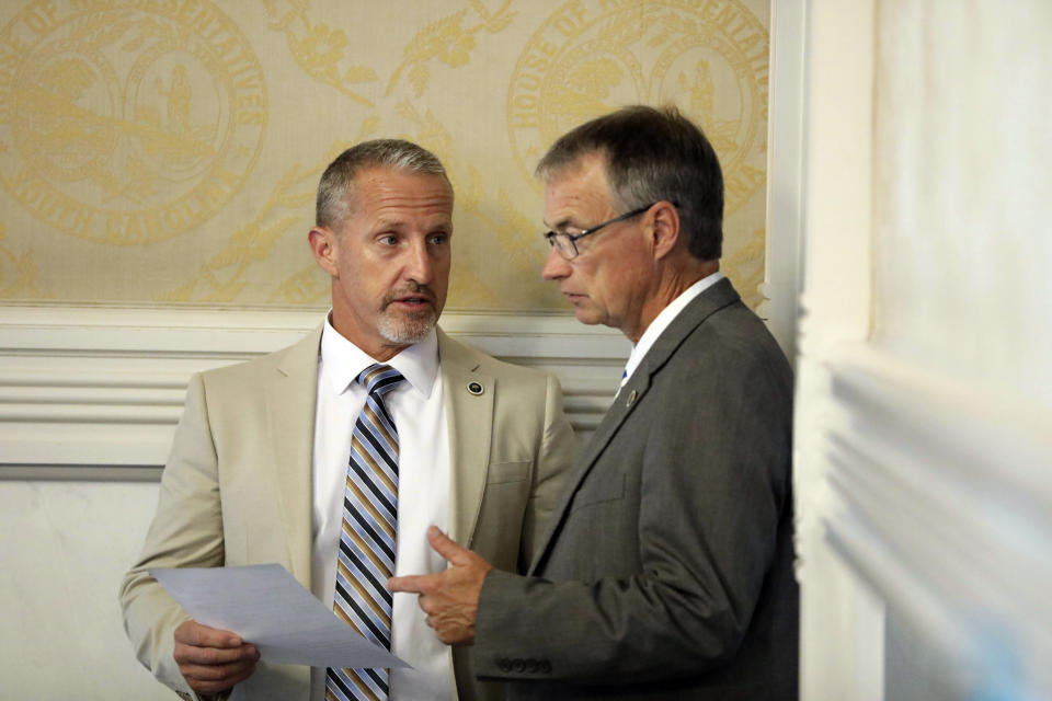 South Carolina Rep. Chris Wooten, R-Lexington, left, talks to Republican House Majority Leader David Hiott, right, before a House session on a total ban on abortion on Tuesday, Aug. 30, 2022, in Columbia, S.C. (AP Photo/Jeffrey Collins)