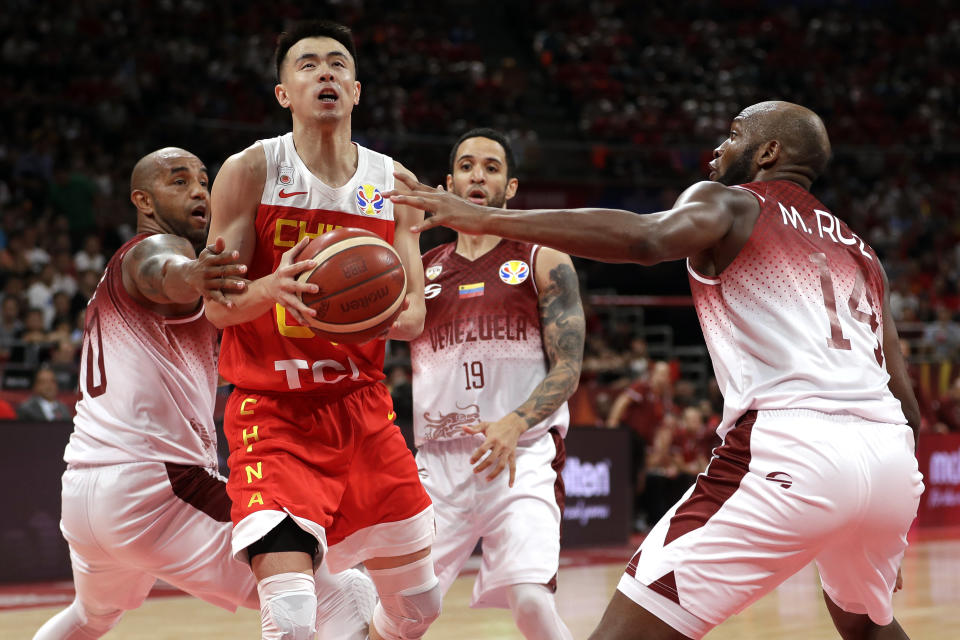 Zhao Jiwei of China goes up for a shot past, from left, Jose Vargas, Heissler Guillent, and Miguel Ruiz of Venezuela during their group phase game in the FIBA Basketball World Cup at the Cadillac Arena in Beijing, Wednesday, Sept. 4, 2019. (AP Photo/Mark Schiefelbein)