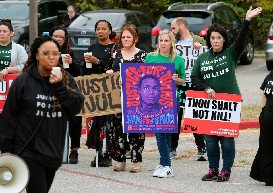 People with signs listen Oct. 26, 2021, as the Rev. Cece Jones-Davis speaks at a rally and march in support of Julius Jones.