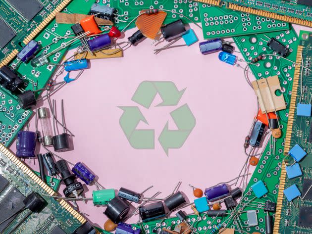 Electronic waste on pink background and green recycling symbol (Photo: Javier Zayas Photography via Getty Images)