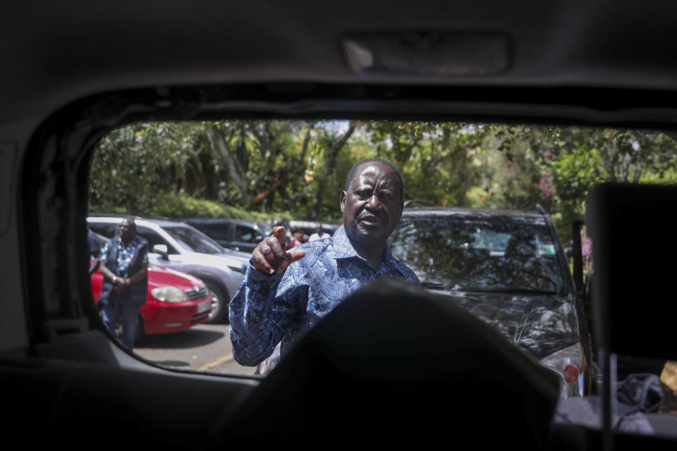 Kenya's opposition leader Raila Odinga points at the shattered rear window of one of his vehicles he says was struck by a teargas canister fired by riot police, at his home in Nairobi, Kenya Friday, March 31, 2023. In an interview with The Associated Press on Friday, Odinga denounced the point-blank firing of a tear gas canister at local journalists during his latest anti-government protest as a "primitive act of intolerance" and vowed to go to court over what he called an attempt on his own life. (AP Photo/Brian Inganga)