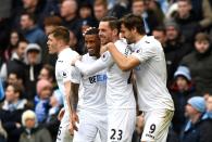 <p>Gylfi Sigurdsson of Swansea City celebrates scoring his sides first goal with team mates during the Premier League match between Manchester City and Swansea City at Etihad Stadium on February 5, 2017 in Manchester, England. </p>