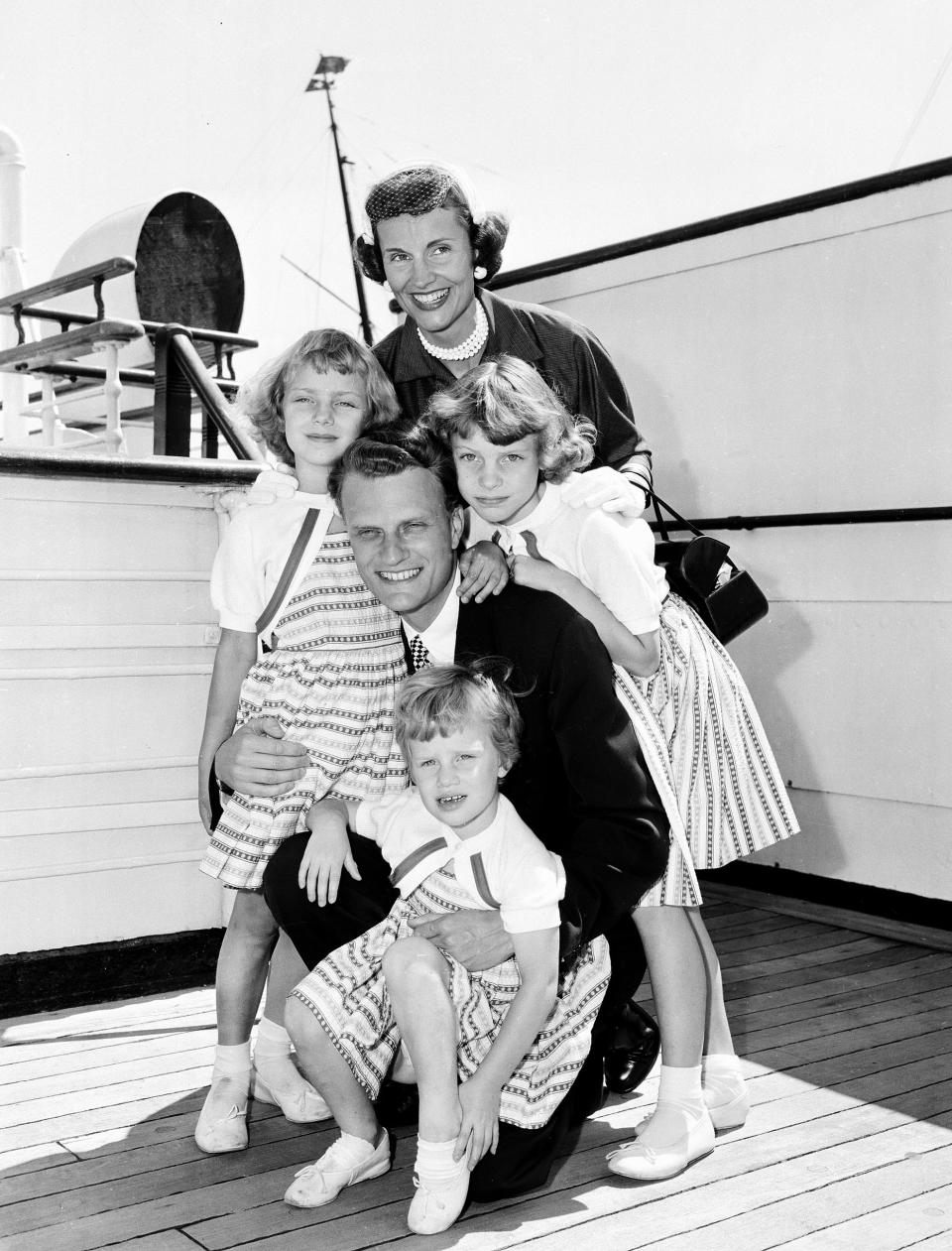 <p>Billy Graham poses with his his wife, Ruth, and their three daughters on the Queen Mary after arriving in New York, July 7, 1954. (Photo: AP) </p>