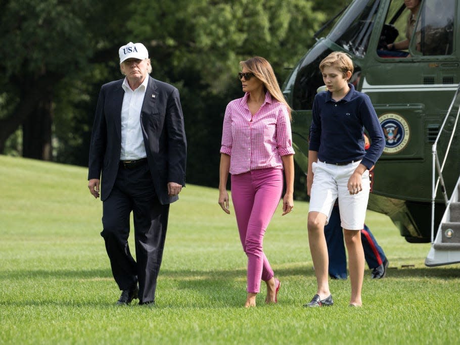 melania trump, donald trump, and barron trump walking across the white house lawn