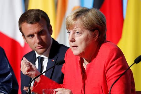 FILE PHOTO: French President Emmanuel Macron (L) and German Chancellor Angela Merkel attend a news conference following talks on European Union integration, defence and migration at the Elysee Palace in Paris, France August 28, 2017. REUTERS/Charles Platiau
