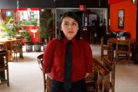 Yasmin Rodr’guez, 18 works as a server poses inside a restaurant in Ecatepec, State of Mexico