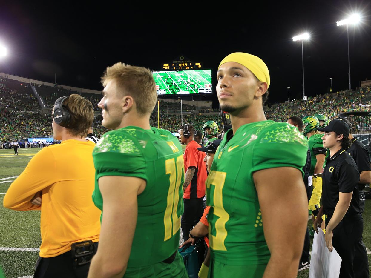 Oregon quarterbacks Bo Nix, left, and Ty Thompson watch the seconds tick off the clock during the game against Hawaii in Eugene on Sept. 16.