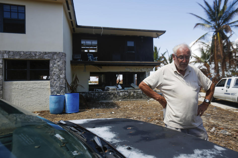 In this Sept. 17, 2019 photo, David Copperthwaite looks down at the ground after taking a break from gathering belongings from his home in Freeport, Grand Bahama Island, Bahamas. Copperthwaite lives in Florida and his son Steve rode out Hurricane Dorian in the home. Steve Copperthwaite said the floodwater was about two feet over the 10-foot-high ceiling of the home, which is built four feet above sea level. (Chris Day/University of Florida via AP)