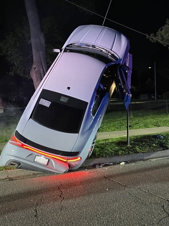 An Ann Arbor crash on April 26, 2024 left a car stuck atop a street sign, police say. (Courtesy Ann Arbor Police Department0