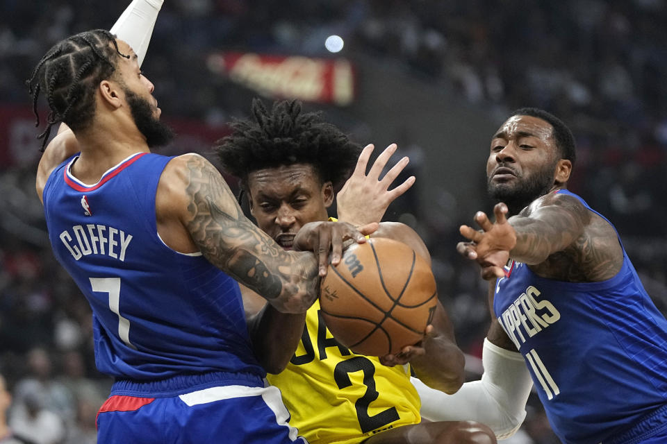 Los Angeles Clippers guard Amir Coffey, left, and guard John Wall, right, grapple for the ball with Utah Jazz guard Collin Sexton during the first half of an NBA basketball game Monday, Nov. 21, 2022, in Los Angeles. (AP Photo/Mark J. Terrill)