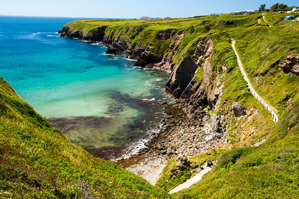 Green cliff tops surrounding a beach