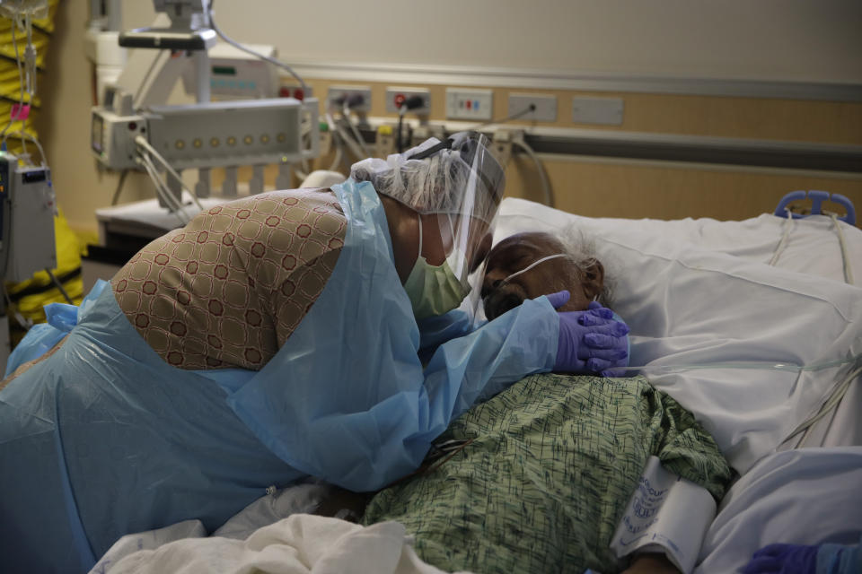 Romelia Navarro llora mientras abraza a su esposo Antonio en su lecho de muerte en el Centro Médico St. Jude de Fullerton, California, el 31 de julio del 2020. Antonio falleció poco después por el COVID-19. (AP Photo/Jae C. Hong)