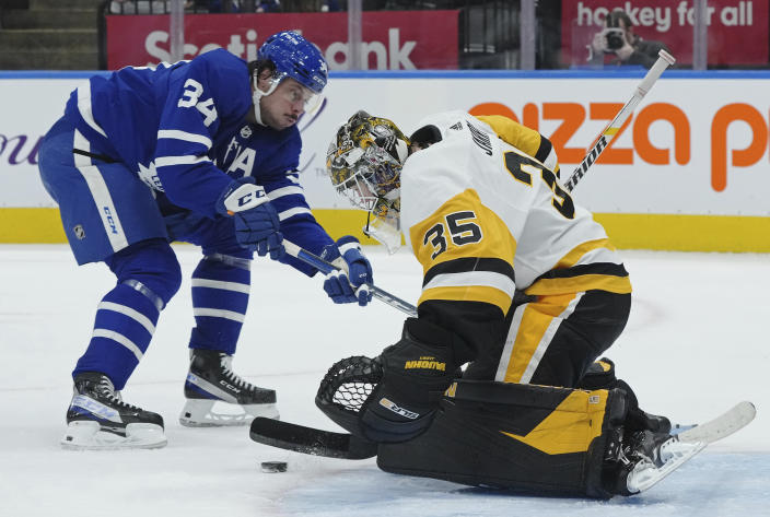 Pittsburgh Penguins goaltender Tristan Jarry (35) stops Toronto Maple Leafs forward Auston Matthews (34) during the second period of an NHL hockey game Thursday, Feb. 17, 2022, in Toronto. (Nathan Denette/The Canadian Press via AP)