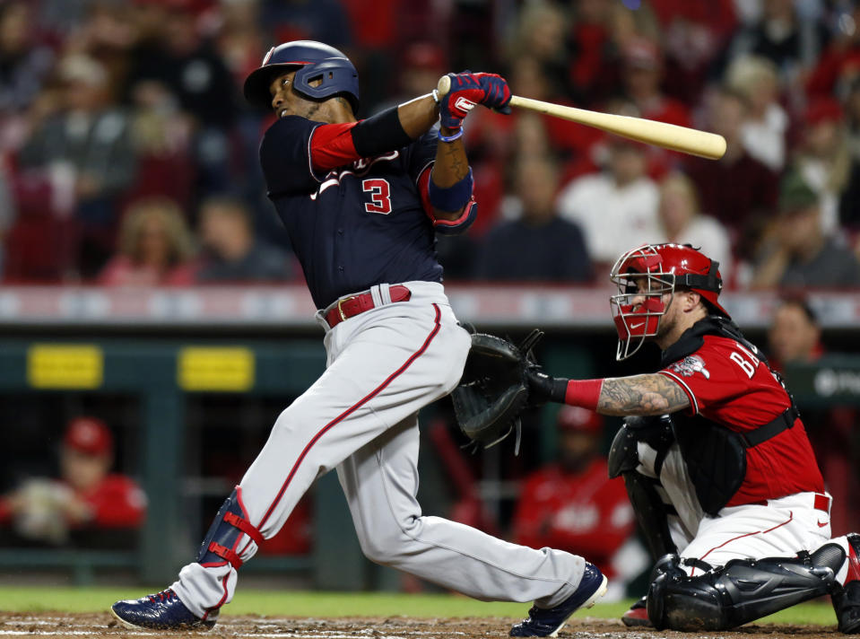 Washington Nationals' Alcides Escobar watches his solo home run in front of Cincinnati Reds catcher Tucker Barnhart during the third inning of a baseball game in Cincinnati, Friday, Sept. 24, 2021. (AP Photo/Paul Vernon)