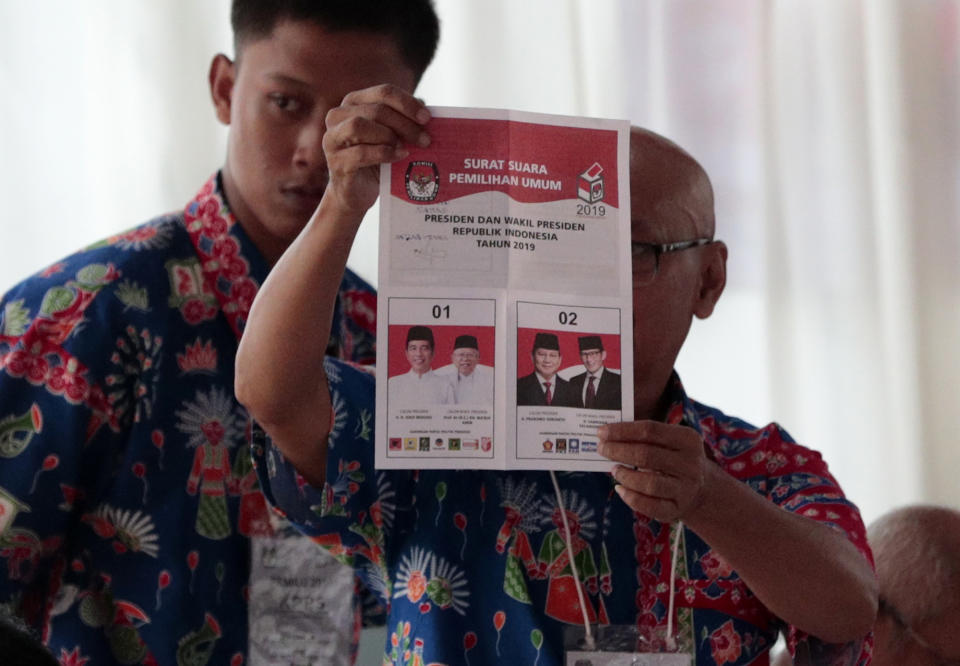 An electoral worker inspects a presidential ballot during the election at a polling station in Jakarta, Indonesia, Wednesday, April 17, 2019. Voting is underway in Indonesia's presidential and legislative elections after a campaign that that pitted the moderate incumbent against an ultra-nationalist former general. (AP Photo/Dita Alangkara)