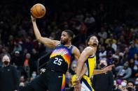 Phoenix Suns forward Mikal Bridges (25) grabs a rebound in front of Indiana Pacers guard Jeremy Lamb, right, during the first half of an NBA basketball game Saturday, Jan. 22, 2022, in Phoenix. (AP Photo/Ross D. Franklin)