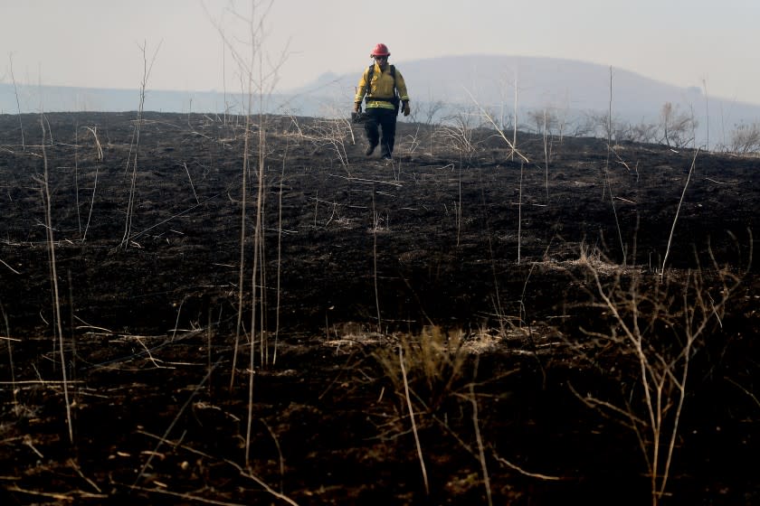 SANTIAGO CANYON, CA. - DEC. 3, 2020. A firefighter walks across a charred hillside as the Bond fire burns more than 7,200 acres in unincorporated Orange County on Thursday, Dec. 3, 2020. (Luis Sinco/Los Angeles Times)