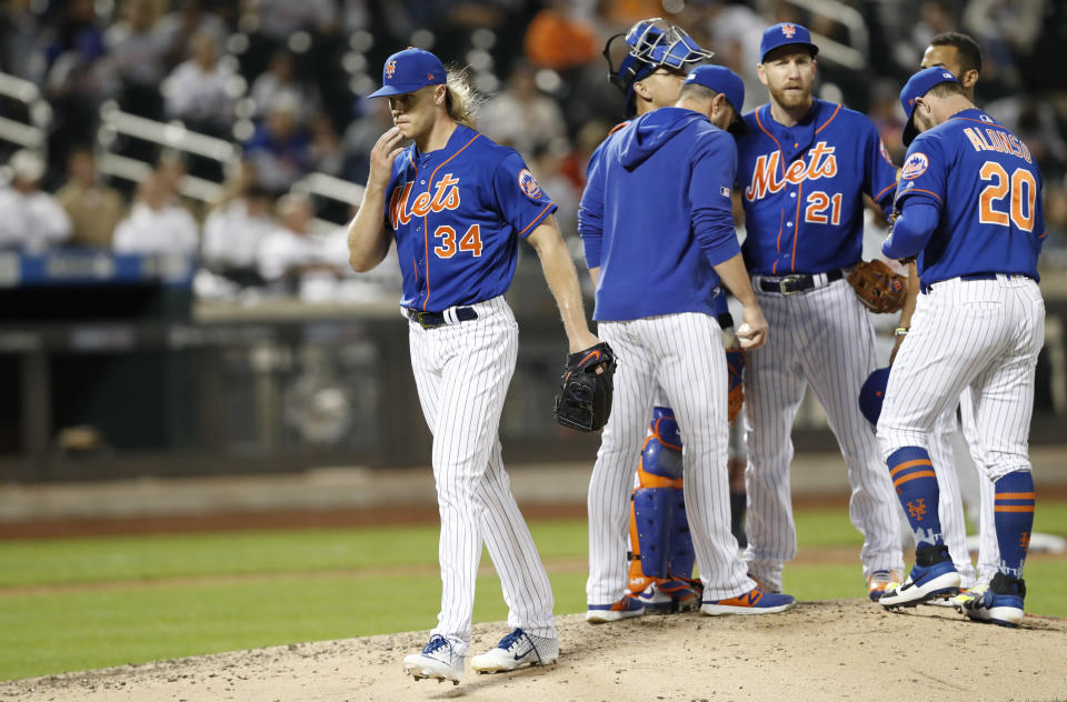 New York Mets starting pitcher Noah Syndergaard (34) leaves the mound after manager Mickey Callaway, second from left, replaced him  during the sixth inning of a baseball game against the Detroit Tigers, Friday, May 24, 2019, in New York. Mets third baseman Todd Frazier (21) and catcher Wilson Ramos (40) also stand on the mound. (AP Photo/Kathy Willens)