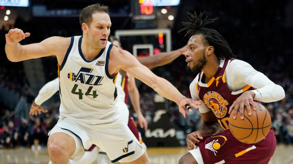 Cleveland Cavaliers' Darius Garland, right, drives to the basket against Utah Jazz's Bojan Bogdanovic (44) in the second half of an NBA basketball game , Sunday, Dec. 5, 2021, in Cleveland. (AP Photo/Tony Dejak)