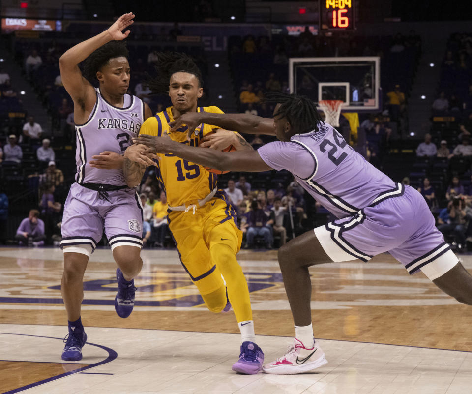 LSU forward Tyrell Ward (15) is fouled on the drive by Kansas State forward Arthur Kaluma (24) as Kansas State guard Tylor Perry (2) defends during an NCAA college basketball game, Saturday, Dec. 9, 2023, at the LSU PMAC in Baton Rouge, La. (Hilary Scheinuk/The Advocate via AP)