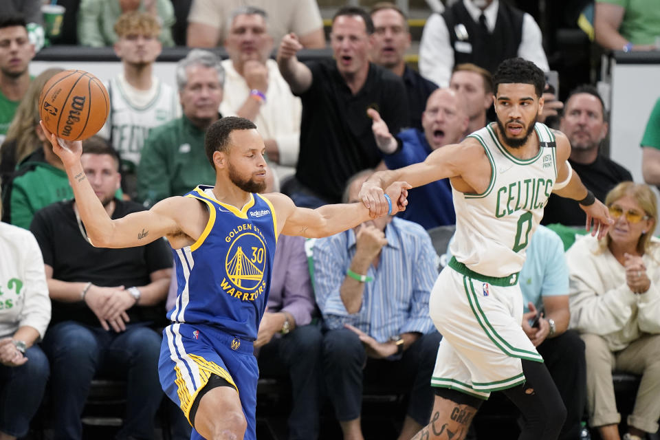 Golden State Warriors guard Stephen Curry (30) looks to pass against Boston Celtics forward Jayson Tatum (0) during the first quarter of Game 6 of basketball's NBA Finals, Thursday, June 16, 2022, in Boston. (AP Photo/Steven Senne)