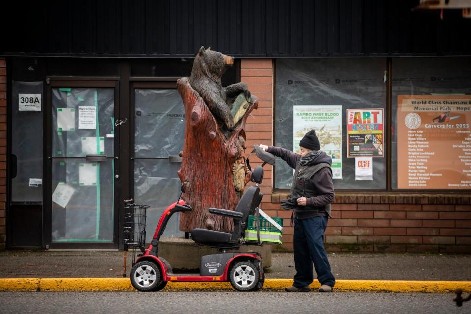 A resident of Hope B.C. stands by his scooter in the town's downtown on Jan. 31. 2024.