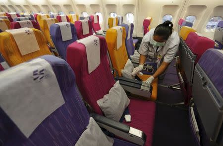 A Thai Airways worker cleans the cabin of an aircraft of the national carrier at Bangkok's Suvarnabhumi International Airport, Thailand, June 18, 2015. REUTERS/Chaiwat Subprasom