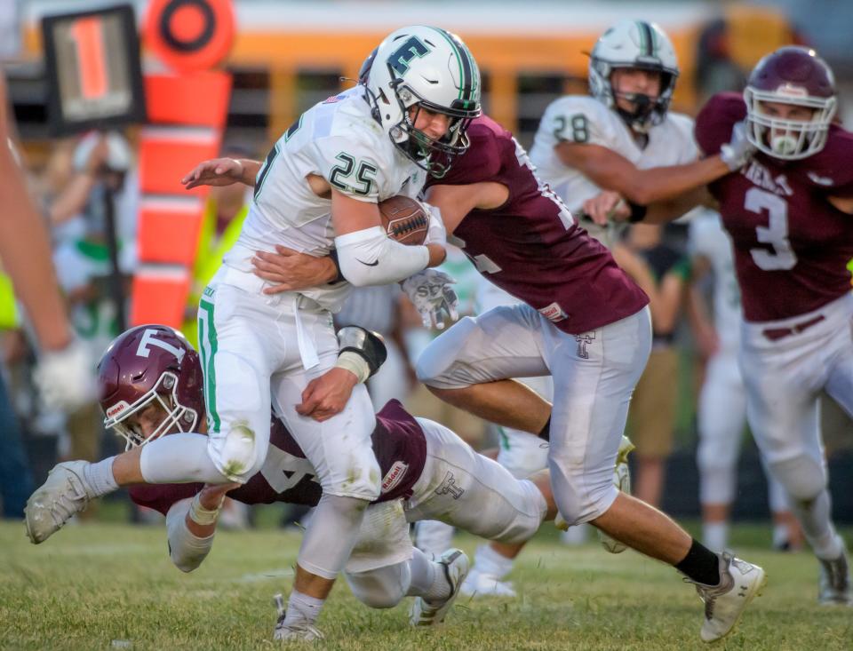 Rylan Bachman (25) moves the ball against a pair of Tremont defenders in the first quarter Friday, Sept. 2, 2022 in Tremont.