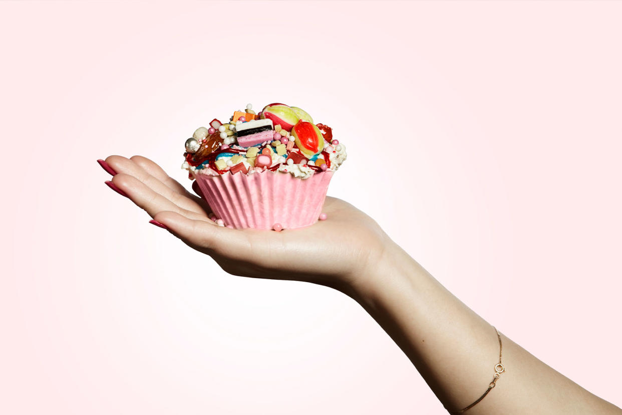 Hand holding a cupcake Getty Images/Paper Boat Creative