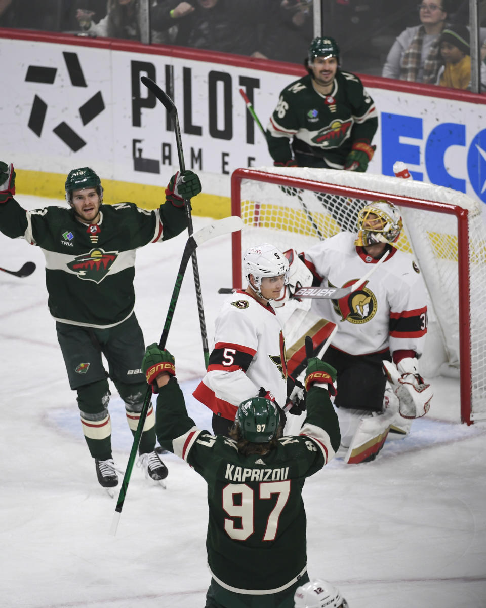 Minnesota Wild left wing Kirill Kaprizov (97) celebrates with center Sam Steel, left, after scoring past Ottawa Senators goalie Anton Forsberg, right, as defenseman Nick Holden (5) looks on during the first period of an NHL hockey game Sunday, Dec. 18, 2022, in St. Paul, Minn. (AP Photo/Craig Lassig)