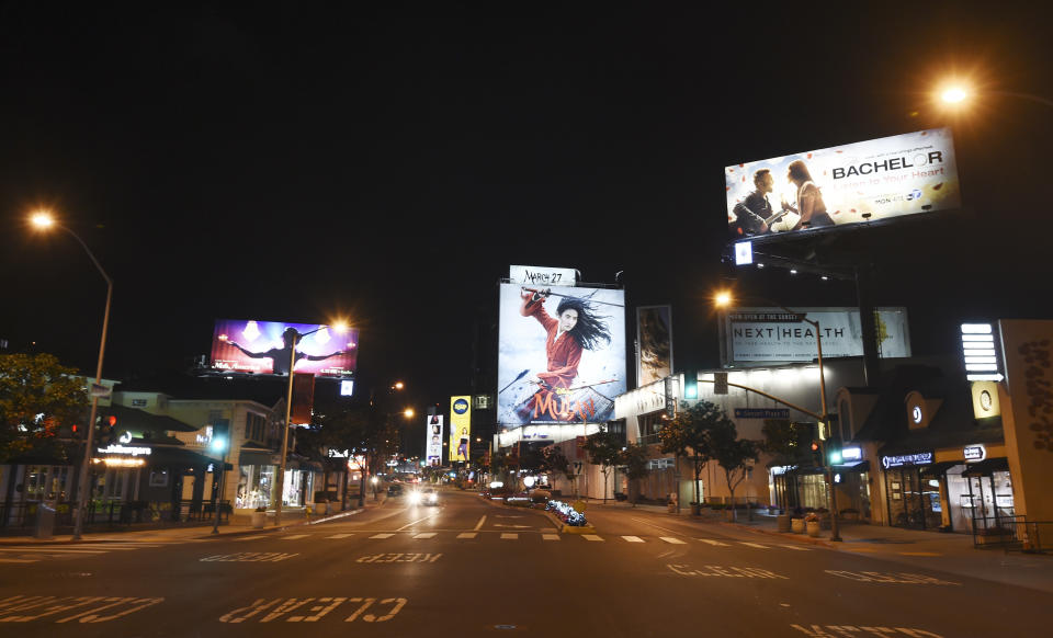 The Sunset Strip is bereft of cars and pedestrians at night as stay-at-home orders continue in California due to the coronavirus outbreak, Wednesday, April 1, 2020, in West Hollywood, Calif. (AP Photo/Chris Pizzello)
