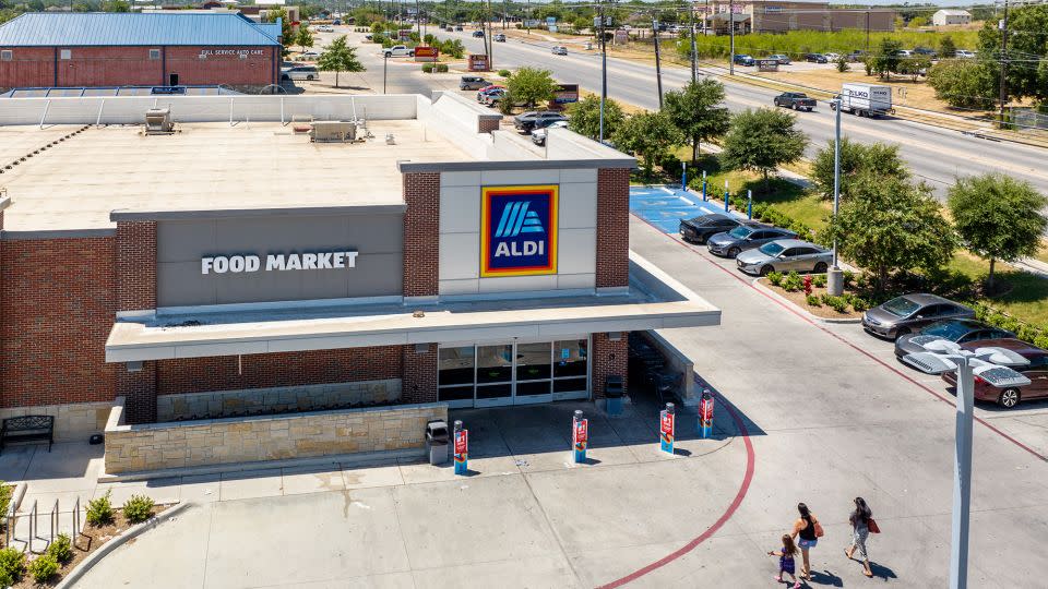 O familie intră într-un supermarket Aldi pe 17 august 2023 în Pflugerville, Texas.  Supermarketul german a achiziționat Winn-Dixie, Harveys Supermarkets și alte magazine alimentare din sud-est, în încercarea de a-și spori prezența în regiune.  - Brandon Bell/Getty Images