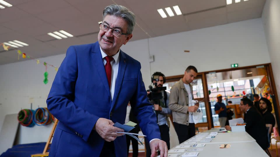 Jean-Luc Melenchon collects voting papers before casting his ballot at a polling station in Paris, June 30, 2024. - Abdul Saboor/Reuters